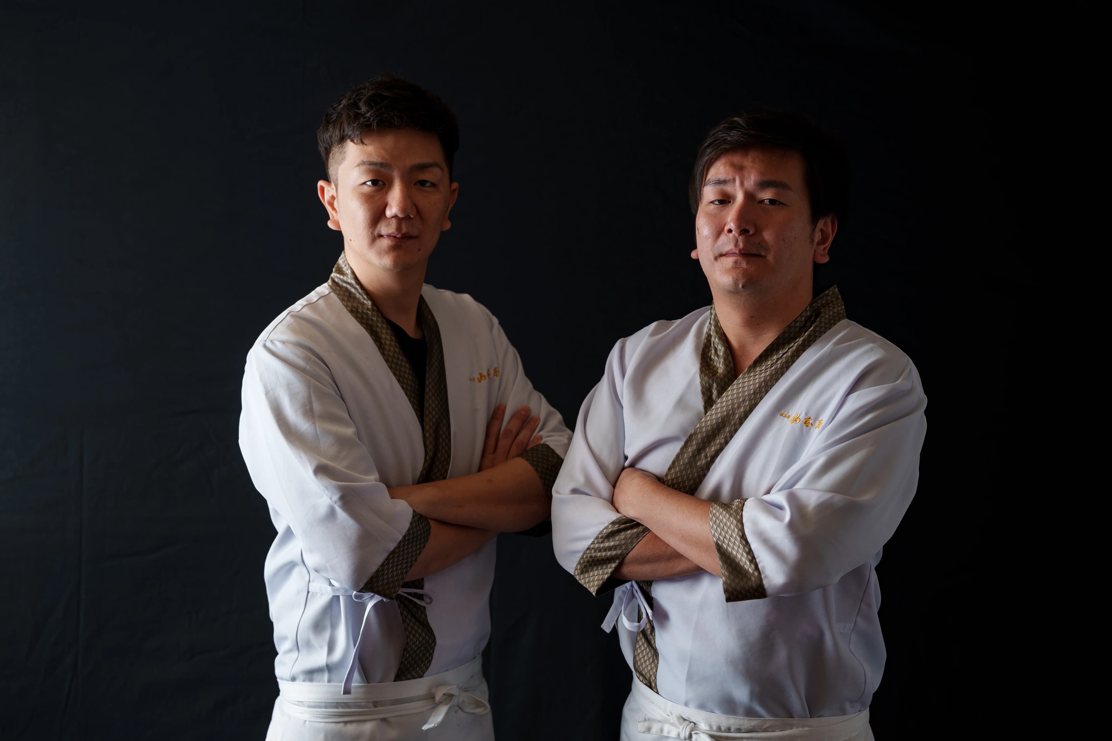 白い作務衣を着た大久手山本屋 五代目 青木裕典・晃佑兄弟