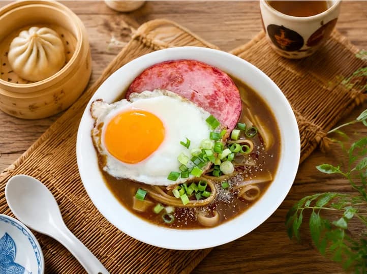 ランチョンミートと目玉焼きをのせた味噌煮込みうどん